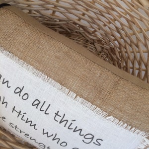 May include: A brown burlap pillow with white fabric trim and the text "I can do all things through Him who gives me strength."