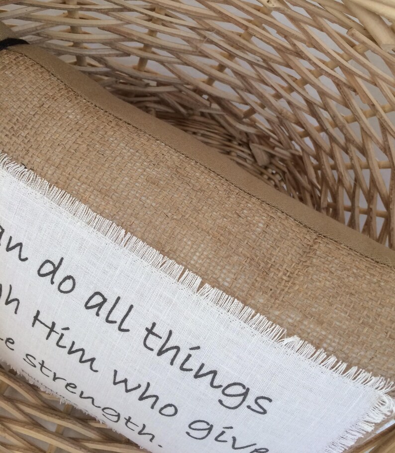May include: A brown burlap pillow with white fabric trim and the text "I can do all things through Him who gives me strength."