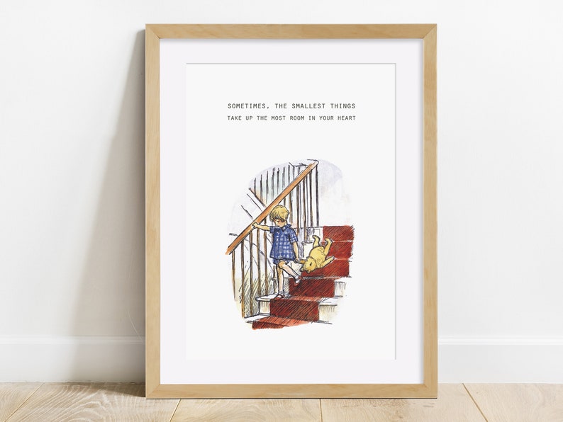 Puede incluir: Una impresi&oacute;n enmarcada con una cita de Winnie de Pooh: "A veces, las cosas m&aacute;s peque&ntilde;as ocupan el mayor espacio en tu coraz&oacute;n." La impresi&oacute;n presenta una ilustraci&oacute;n de acuarela de un ni&ntilde;o subiendo una escalera con un oso de peluche.