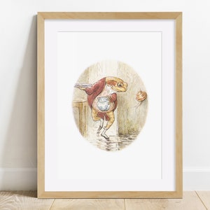 May include: A framed illustration of a frog wearing a red jacket and holding a pitcher, walking towards a plate on a table. The frog is in a circular frame with a brown background.