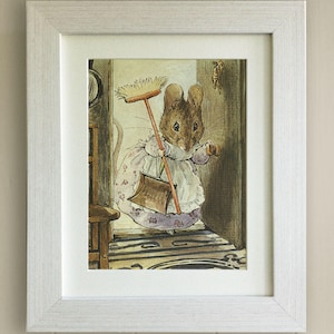 May include: A framed illustration of a mouse wearing a dress and holding a broom and dustpan. The mouse is standing in a doorway and looking out at the viewer. The illustration is in a white frame.