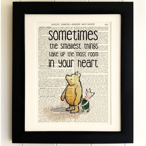 Könnte beinhalten: Eine Illustration von Winnie Puuh und Ferkel, gedruckt auf einer alten Buchseite. Der Text lautet: "Manchmal nehmen die kleinsten Dinge den meisten Platz im Herzen ein."