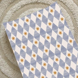 May include: A rectangular fabric featuring a repeating pattern of blue diamond shapes and gold starbursts on a cream background. Suitable for home decor or craft projects.