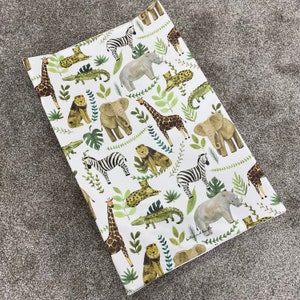 K&ouml;nnte beinhalten: Wei&szlig;er Wickelauflagenbezug mit einem Dschungeltier-Druck. Der Druck zeigt Zebras, Elefanten, Giraffen, Nash&ouml;rner, Krokodile, L&ouml;wen und eine Vielzahl von gr&uuml;nen Blattpflanzen.