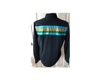 Puede incluir: Una camisa de manga larga azul marino con una franja horizontal de cinta turquesa, verde y dorada en la espalda.