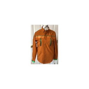 Op de afbeelding: Een overhemd met lange mouwen en knoopsluiting in een effen roestoranje kleur. Het overhemd heeft een horizontale band van glanzend oranje lint over de borst, twee verticale groene lintaccenten op de borst en groene lintafwerking aan de mouwboorden.