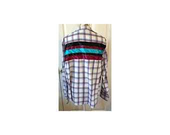 Puede incluir: Una camisa de manga larga a cuadros blancos, azules y rojos con un diseño de cinta turquesa, negra y burdeos en la espalda.