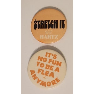 May include: Two round, orange and white buttons with text. The first button is orange with black text that reads "Stretch It" and "See Hartz". The second button is white with orange text that reads "It's No Fun To Be A Flea Anymore".