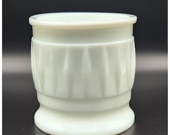 May include: White ceramic vase with a fluted design. The vase has a round base and a cylindrical body.
