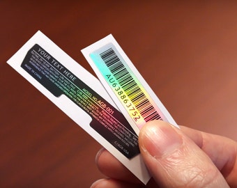 May include: Two white labels with black text and a holographic barcode. The top label reads "AU638863752" and the bottom label reads "MODEL NO. AGB-001". The text on the bottom label continues with "RATING IV-QEW BATTERY LAS JAAZ 2000 Patents issued and Pending, See..."