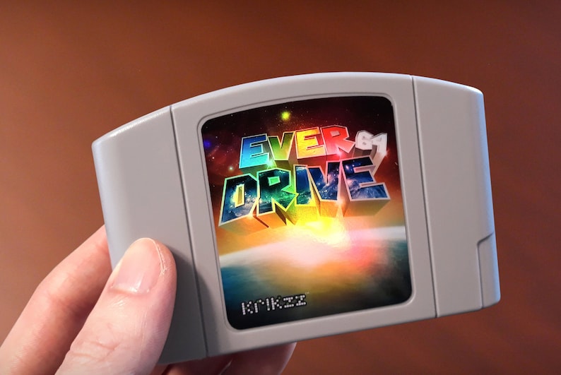 Op de afbeelding: Een grijze Nintendo 64-gamecartridge met een kleurrijk label met de tekst "EVERDRIVE" in 3D-stijl. Het label heeft ook een kleurrijke, abstracte achtergrond.