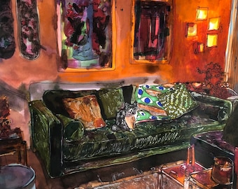 May include: A green velvet sofa with a cat sitting on it. The sofa has a patterned throw pillow and is in a room with a rug, a coffee table, and artwork on the walls.