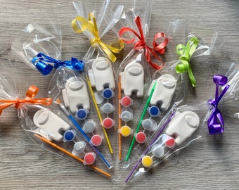 Puede incluir: Un conjunto de seis favores de personajes de Among Us para pintar. Cada favor incluye un personaje blanco, un pincel y un pequeño recipiente de pintura.