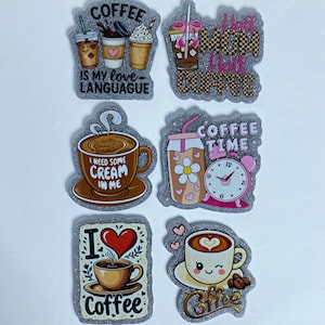 May include: A set of six glittery, die-cut stickers featuring coffee-themed illustrations and text. Designs include cups of coffee, iced drinks, a clock, and hearts with phrases like COFFEE IS MY LOVE LANGUAGE, HALF MOM HALF COFFEE, and I NEED SOME CREAM IN ME.