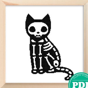 Op de afbeelding: Zwart-witte kruissteekpatroon van een skeletkat die zit met zijn staart om zijn lichaam gewikkeld. Het patroon is ingelijst en tentoongesteld op een houten ezel. De afbeelding bevat ook een groen en wit PDF-label met de tekst "Fluffy Fuzzy PDF Cross Stitch".