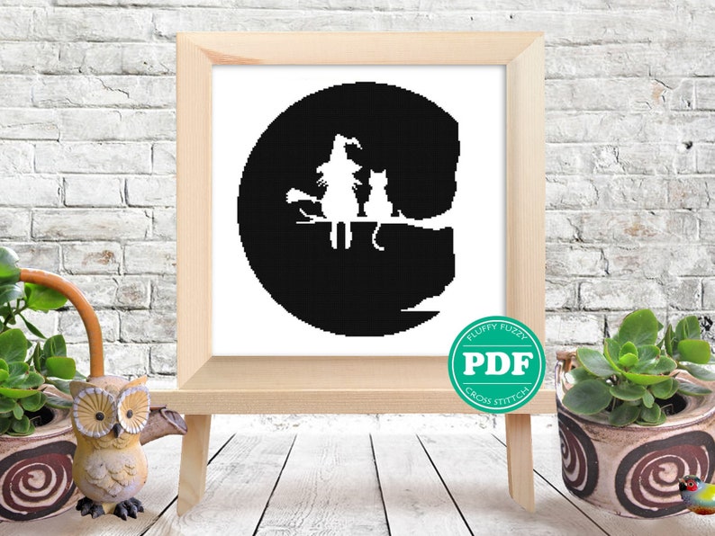 May include: Black and white cross stitch pattern of a witch and a cat sitting on a branch in front of a full moon. The pattern is in a circular frame and has the text "PDF" in a green circle.