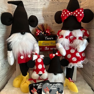 May include: A collection of Mickey and Minnie Mouse-themed gnomes. The gnomes have black hats with mouse ears, white beards, and red and white polka dot outfits. Two cards with the text "It all started with a Mouse" are also present.