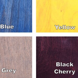 May include: A close-up image showcasing four wood samples with different colors and the names of the colors. The colors are blue, yellow, grey, and black cherry. The text is in a white, sans-serif font.