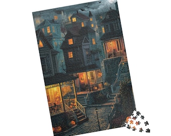 May include: A Halloween-themed jigsaw puzzle depicting a spooky neighborhood scene. The image shows houses with lit windows and porches, jack-o'-lanterns, and bats in the night sky. A few puzzle pieces are scattered in the corner.