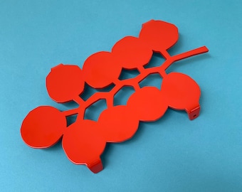 A RED tomato trivet made of powder coated steel for all your hot pots, pans and other hot stuff