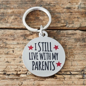 Médaille pour chien personnalisée - Médaille d'identité amusante à slogan « Je vis toujours avec mes parents », médaille gravée pour le nom d'un animal de compagnie, laiton plaqué argent