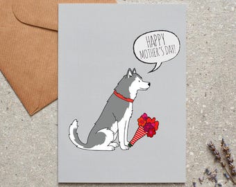 Könnte beinhalten: Graue Muttertagskarte mit einem Cartoon-Husky-Hund mit rotem Halsband, der einen Strauß roter und rosa Blumen hält. Die Sprechblase sagt: „Alles Gute zum Muttertag!“ Ein Umschlag ist im Hintergrund zu sehen.