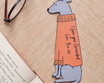 Könnte beinhalten: Ein grauer und orangefarbener Lesezeichen in Form eines Hundes, der einen Pullover trägt. Das Lesezeichen hat den Text "I love you Grandad" und "Love Ben XXX" darauf.