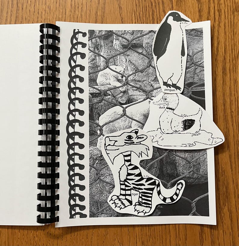 May include: A black and white notebook with a spiral binding. The notebook has a black and white photo of a polar bear in a cage. There are three cut-out images of animals on the page: a penguin, a duck, and a tiger. The penguin is standing on top of the duck, and the duck is standing on top of the tiger. The tiger is labeled "tiger" and the duck is labeled "duck". The penguin is labeled "penguin".