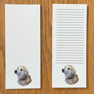 May include: Two white notepad sets with lined paper. Each notepad features a brown and white dog illustration.