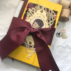 handmade altered book junk journal with ribbon tie and decorated cover.