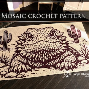 May include: A rectangular mosaic crochet pattern featuring a dark maroon bearded dragon centered on a cream background. The design includes two saguaro cacti and desert brush. The text MOSAIC CROCHET PATTERN and Loops Obscure designs are visible.