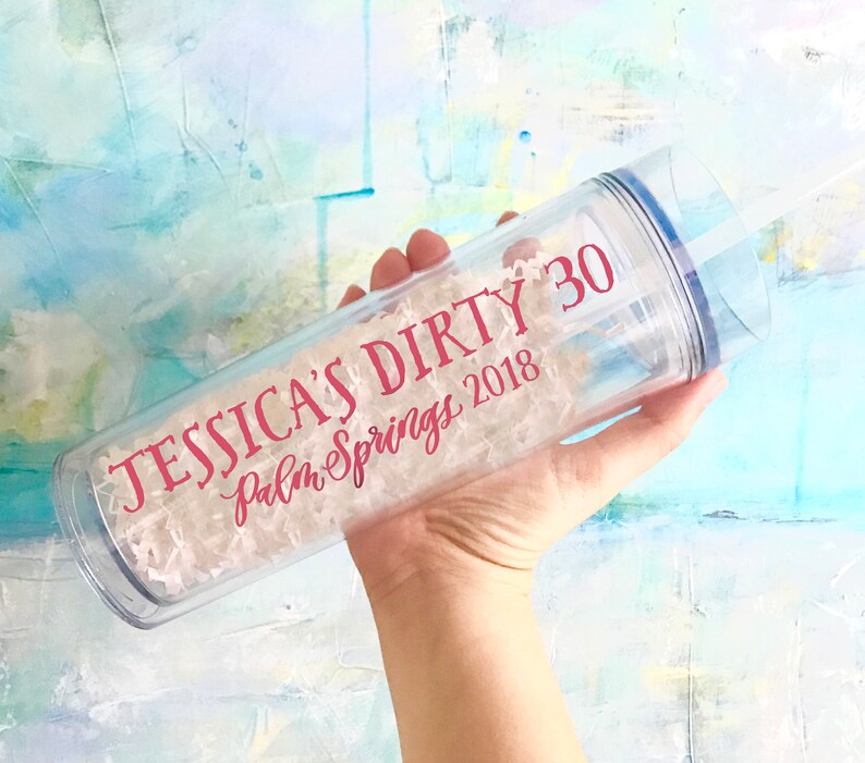 May include: Clear plastic tumbler with a pink inscription that reads "Jessica's Dirty 30 Palm Springs 2018".
