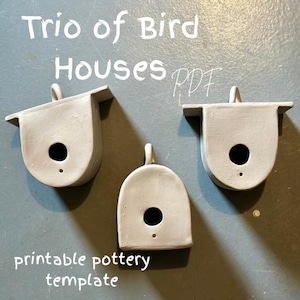 May include: Three grey ceramic birdhouses with round openings. The birdhouses are designed to be hung. The image includes the text "Trio of Bird Houses PDF Printable Pottery Template".