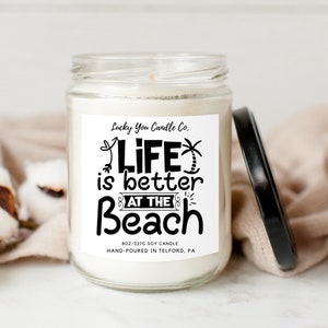 May include: A white soy candle with a black label that reads "Lucky You Candle Co. Life is better at the Beach" and "8 oz/227g Soy Candle Hand-Poured in Telford, PA".