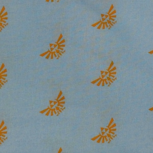 May include: Light blue fabric with a repeating pattern of orange stylized bird crests. The crests are evenly spaced across the fabric, creating a consistent design. The fabric has a slightly textured appearance.