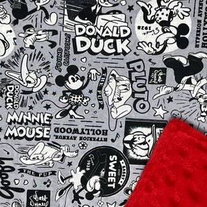 Peut inclure: Tissu gris avec des personnages de dessins anim&eacute;s en noir et blanc, tels que Mickey Mouse, Donald Duck et Pluto. Un coin rouge textur&eacute; est visible.