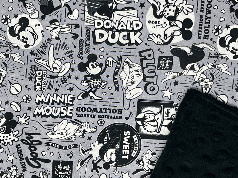 Peut inclure: Un tissu gris avec un motif de dessin anim&eacute; en noir et blanc repr&eacute;sentant Mickey Mouse, Minnie Mouse, Donald Duck et Pluto. Le motif comprend des &eacute;l&eacute;ments textuels tels que "Donald Duck", "Minnie Mouse" et "Goofy".