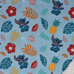 May include: A blue and white fabric with a repeating pattern of Stitch from Lilo & Stitch wearing a grass skirt, pineapples, and tropical leaves.