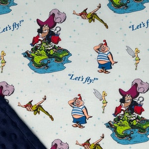 May include: A blue and white fabric with a repeating pattern of Peter Pan, Captain Hook, Tinkerbell, and the phrase "Let's fly!"
