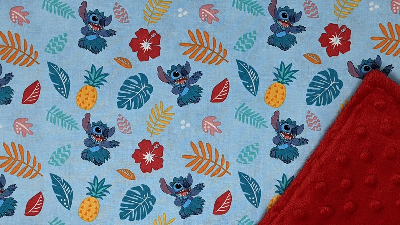 May include: A blue and red fabric baby blanket with a repeating pattern of Stitch from Lilo & Stitch. Stitch is wearing a lei and hula dancing. The pattern also includes pineapples, hibiscus flowers, and tropical leaves. The blanket is reversible with a red minky fabric on the back.