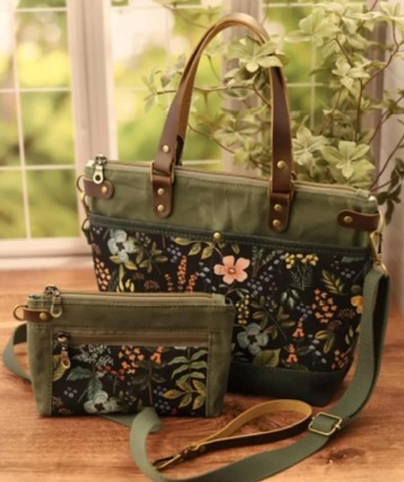 Puede incluir: Dos bolsos de lona verde con estampados florales y asas de cuero marr&oacute;n. El bolso m&aacute;s grande tiene una correa para el hombro. El bolso m&aacute;s peque&ntilde;o tiene una cremallera.