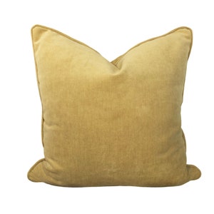 May include: A soft, mustard yellow throw pillow with a simple, rectangular shape and a subtle texture.