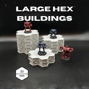 May include: Image of Large Hex Buildings with miniature figures. The buildings are light gray, hexagonal platforms with a textured design. The figures are red and blue robots. The text "LARGE HEX BUILDINGS" is at the top. The image includes a 33 mm measurement.