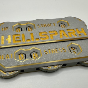 Puede incluir: Un rastreador de juego impreso en 3D gris y dorado con las palabras "Hellspark" y "Struct" en la parte superior. El rastreador tiene diales para "HP", "Calor", "Estrés" y "Struct".