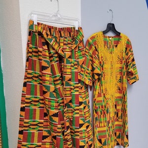 May include: A two-piece outfit with a skirt and a top. The skirt is a long, flowing skirt with a colorful African print. The top is a short-sleeved shirt with a similar print. The outfit is made of a soft, comfortable fabric and is perfect for any occasion.