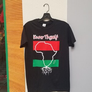May include: Black t-shirt with a graphic of the continent of Africa in red, black, and green with the words "Know Thyself" and "Roots" printed on the shirt.