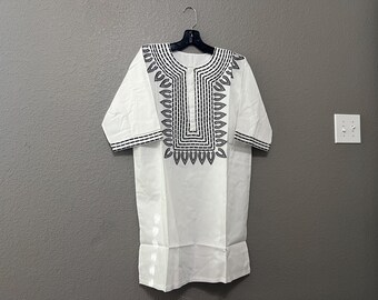 May include: A white short-sleeved shirt with a black geometric design on the neckline.