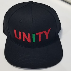 May include: A black baseball cap with a red and green embroidered "UNITY" on the front.