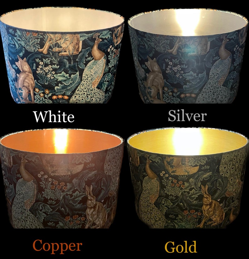 Op de afbeelding: Vier lampenkappen met een bos sc&egrave;ne met pauwen, vossen en konijnen. De lampenkappen worden getoond in vier verschillende kleuren: wit, zilver, koper en goud.