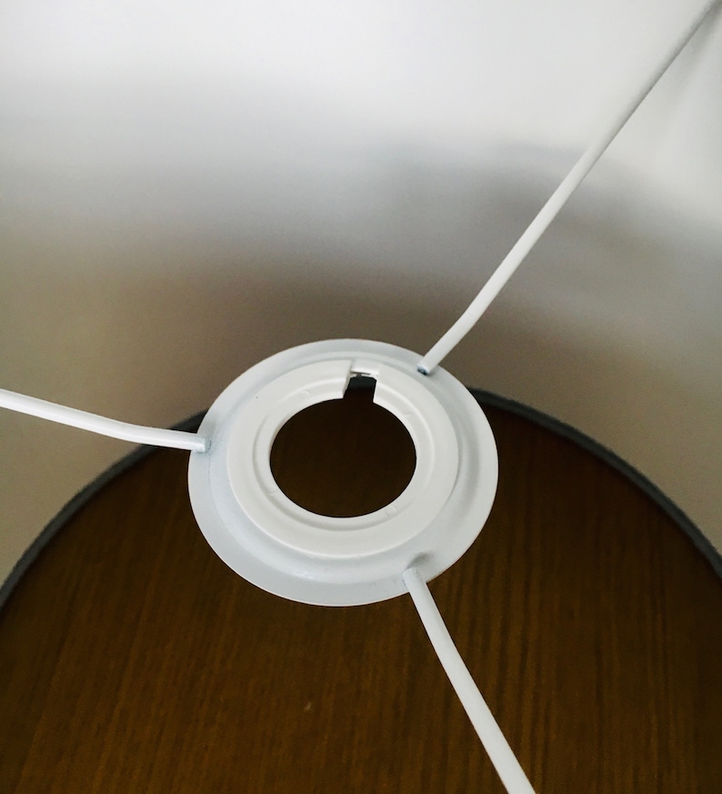 Op de afbeelding: Witte lampenkap met een witte kunststof fitting en drie witte snoeren.